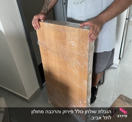 מוביל מחזיק פלטת עץ עטופה בניילון נצמד להגנה בעת הובלה